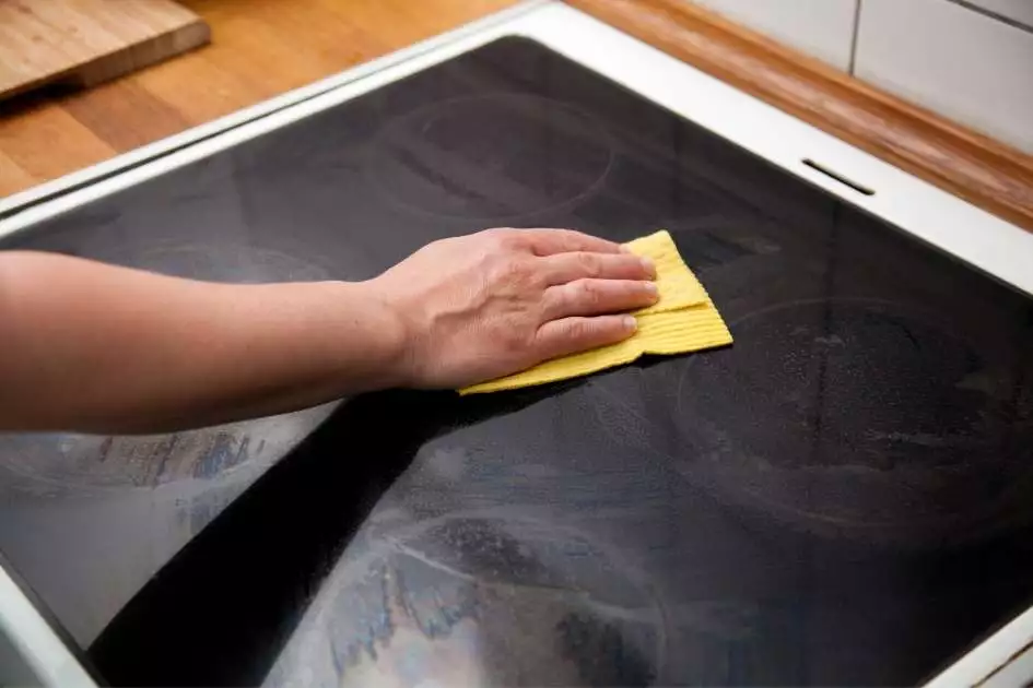 Cleaning a Ceramic Hob with a Yellow Kitchen Cloth