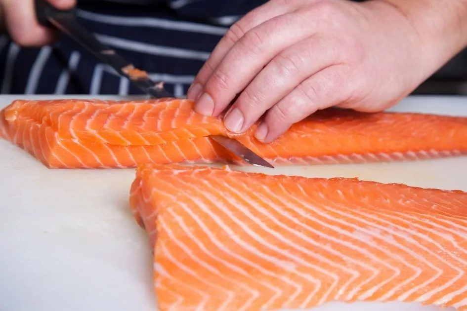 chef slicing salmon with a fillet knife