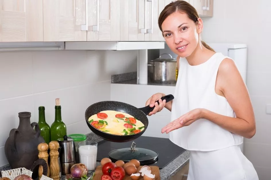 a lady holding an omelet pan